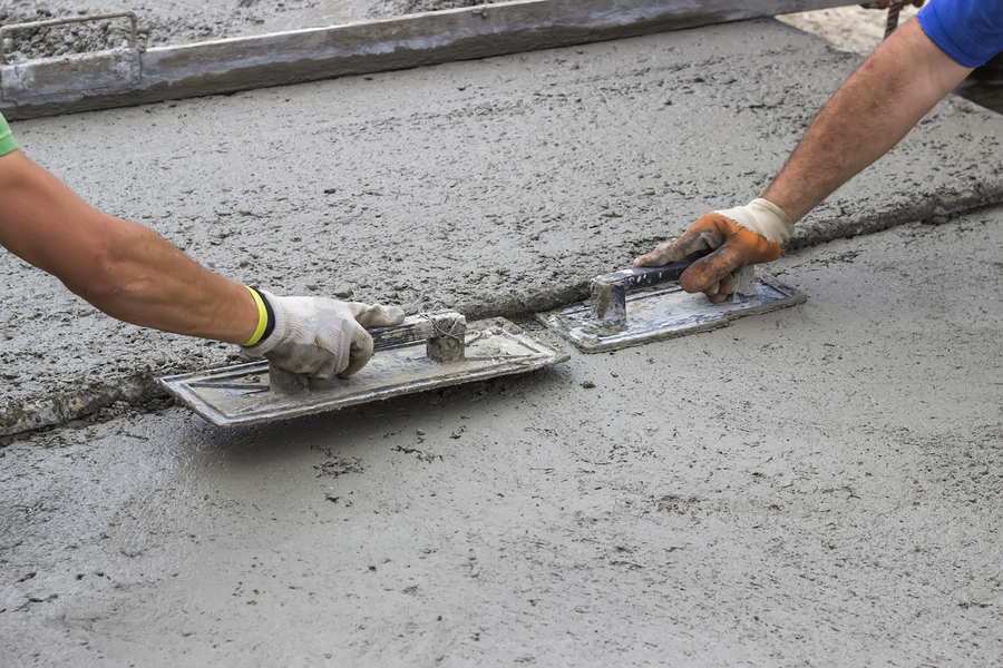 leveling concrete with trowels mason hands spreading poured concrete